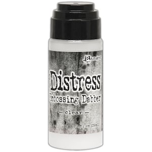 May include: A clear Distress Embossing Dabber bottle with a black top. The bottle has a distressed gray background with the word "Distress" in large letters. The bottle contains 1 fl oz (29ml) of clear embossing dabber.
