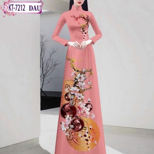 May include: A pink long-sleeved dress with a mandarin collar and a floral print. The dress features a large gold circle with a Chinese character in the center. The dress is called "KT-7212 DAU".