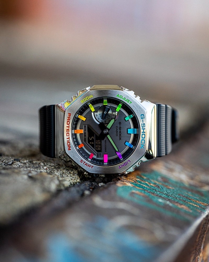 Casio Casioak G shock with stainless steel bezel and black rubber straps. Bezel text and hour markers are painted in a beautiful rainbow gradient