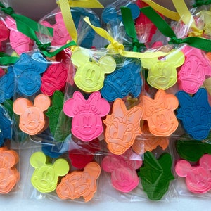 Könnte beinhalten: Sortiment von bunten, einzeln verpackten Buntstiften in Form von Mickey Mouse, Minnie Mouse und Donald Duck Figuren.