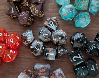 May include: A collection of various colored and patterned dice, including black, white, red, green, and blue dice with gold flecks. The dice are made of resin and have a variety of numbers on their faces.