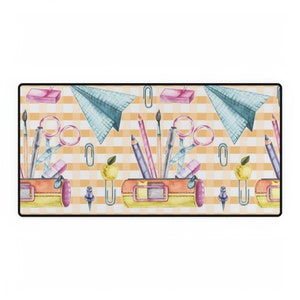 Peut inclure: Tapis de bureau rectangulaire avec un motif répété de fournitures scolaires. Le motif comprend des trousses, des crayons, des ciseaux, des avions en papier et des pommes sur un fond à carreaux jaune et blanc.