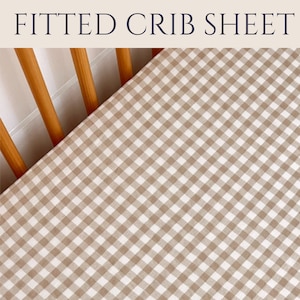 May include: A fitted crib sheet in a brown and white gingham pattern. The sheet is made of soft, breathable fabric and is perfect for keeping your baby comfortable and cozy.