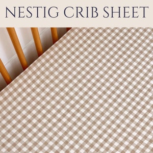 May include: A brown and white gingham crib sheet. The sheet is fitted and has a checkered pattern.