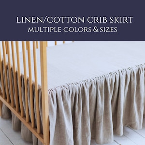 May include: A crib skirt made of linen and cotton in a neutral beige color. The skirt has a gathered, ruffled design and is shown on a wooden crib. The text "LINEN/COTTON CRIB SKIRT MULTIPLE COLORS & SIZES" is displayed at the top.