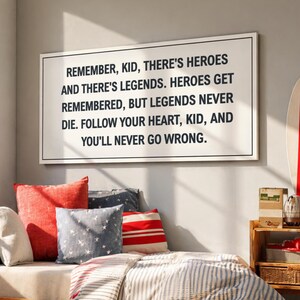 May include: A cozy bedroom scene with a wooden daybed, pillows, and a striped comforter. A framed sign on the wall reads, "REMEMBER, KID, THERE'S HEROES AND THERE'S LEGENDS." A surfboard and small wooden shelf add to the decor.