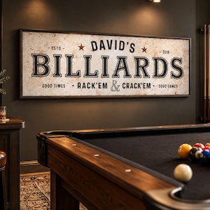 May include: A rectangular wall sign with a distressed off-white background and a dark frame. The text reads DAVID'S BILLIARDS, ESTD 2018, and GOOD TIMES - RACK'EM & CRACK'EM - GOOD GAMES. Two small brown stars flank the name in black lettering.
