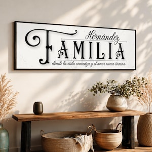 May include: A framed sign with the word "FAMILIA" in black script, above the name "Hernandez". The sign is above a wooden bench with decorative baskets and vases. The text "donde la vida comienza y el amor nunca termina" is below the word "FAMILIA".