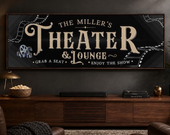 May include: A rectangular wall sign with a black background and a dark wood frame. The text reads THE MILLER'S THEATER & LOUNGE, GRAB A SEAT, ENJOY THE SHOW. It features beige lettering, a film reel icon, and film strip graphics on the corners.