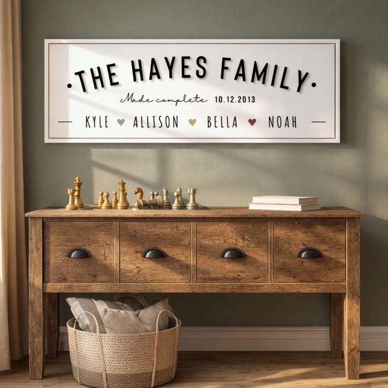 Puede incluir: Un letrero de madera con el texto "THE HAYES FAMILY" en letras negras. Debajo, el texto "Made complete 10.12.2013" y los nombres de la familia. El letrero est&aacute; sobre una consola de madera con piezas de ajedrez y una cesta de mimbre.