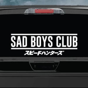 May include: A black truck with a white decal that says "SAD BOYS CLUB" and "スピーディー ハンターズ" in Japanese characters.