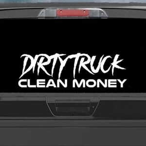 May include: A black pickup truck with a white vinyl decal on the rear window that reads "DIRTY TRUCK CLEAN MONEY".