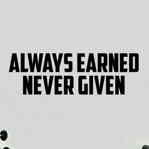 May include: Black and white motivational quote wall decal that reads "ALWAYS EARNED NEVER GIVEN". The decal is displayed on a white wall in a gym setting with weights in the background.