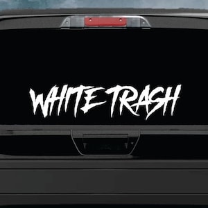 May include: A black pickup truck with a white vinyl decal on the rear window that reads "WHITE TRASH" in a stylized font.