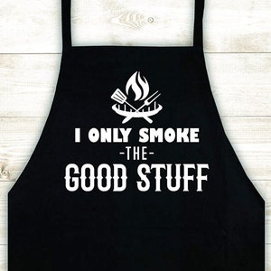 May include: Black apron with white text that reads "I only smoke -the- good stuff" and a graphic of a grill with flames.