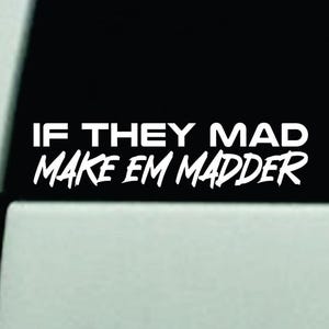 May include: White vinyl decal with the text "IF THEY MAD MAKE EM MADDER" in a bold, sans-serif font. The decal is displayed on a black background, likely a car window.