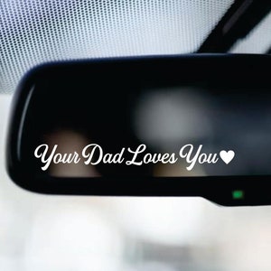 May include: A rearview mirror with a white vinyl decal that reads "Your Dad Loves You" with a heart symbol.