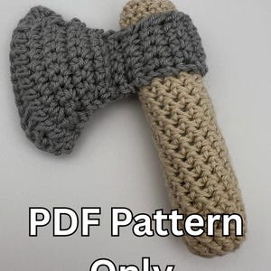 Op de afbeelding: Gehaakt bijl speelgoed met een grijs hoofd en een beige handvat. De tekst "PDF Pattern Only" is afgedrukt onder het speelgoed.