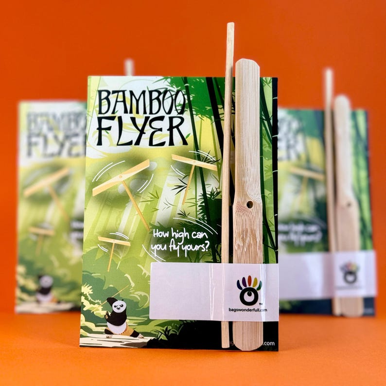 a bamboo flyer with a bamboo stick attached to it, set against a green and orange background.