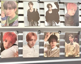 May include: A collection of eight photo cards featuring different individuals. The cards showcase various poses and hairstyles, with a range of outfits. The cards are displayed in protective sleeves, arranged in a grid-like pattern.