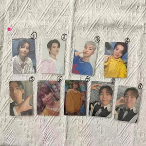 Könnte beinhalten: Eine Sammlung von neun rechteckigen Fotokarten mit Bildern von Personen. Die Karten sind auf einer weißen, strukturierten Oberfläche angeordnet. Jede Karte zeigt eine andere Person mit unterschiedlichen Posen und Outfits.