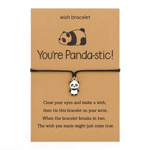 Op de afbeelding: Een wensarmband met een zwart koord en een pandabedeltje. De kaart leest "You're Panda-stic!" met instructies over het doen van een wens. De pandabedeltje is zwart en wit.