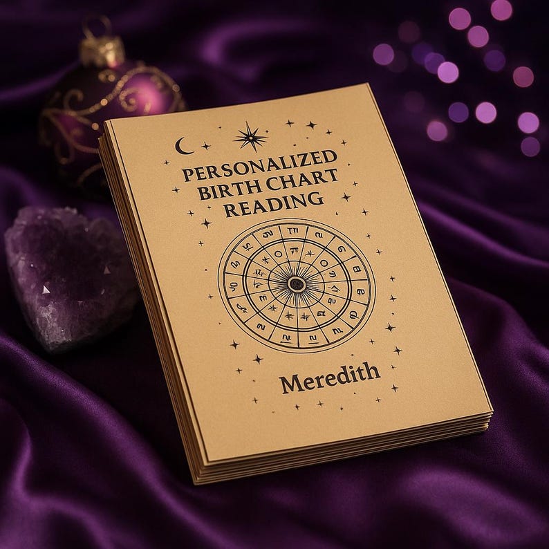 May include: A stack of personalized birth chart readings with the name "Meredith" printed on the cover. The cover is tan with black text and a circular astrological chart design. The background is a deep purple satin fabric.