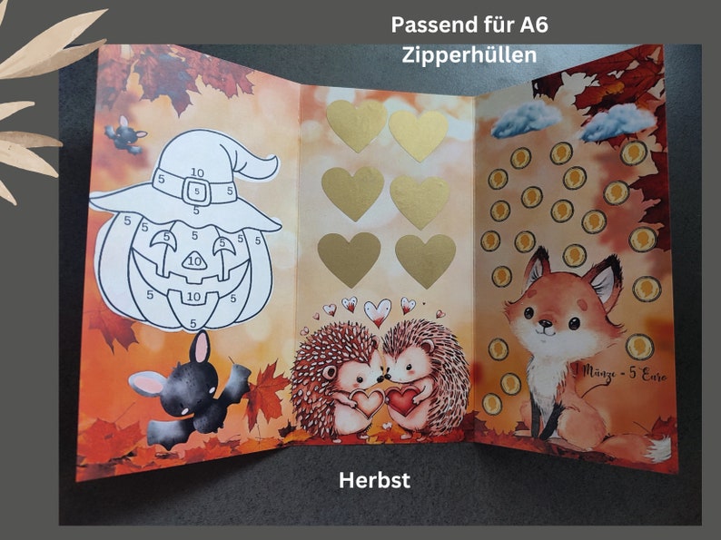 May include: A tri-fold card featuring autumn leaves, a pumpkin with numbers, a bat, six gold hearts, two hedgehogs, and a fox with coin icons. Text reads Passend f&uuml;r A6 Zipperh&uuml;llen and Herbst. The fox graphic includes the text 1 M&uuml;nze - 5 Euro.