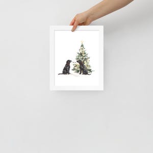 Puede incluir: Dos labradores negros se sientan frente a un &aacute;rbol de Navidad decorado. Los perros se miran y parecen estar jugando con una cadena de luces.