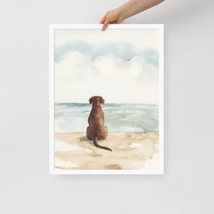 May include: Watercolor painting of a brown dog sitting on a beach, looking out at the ocean. The dog has a red collar and is facing away from the viewer. The sky is blue with white clouds.