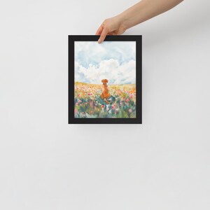 May include: A framed watercolor painting of a dog sitting in a field of flowers. The dog is brown and white and is looking away from the viewer. The flowers are a variety of colors, including pink, purple, and yellow.