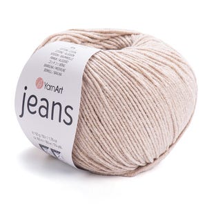 Op de afbeelding: Een bol beige YarnArt Jeans garen. Het etiket toont de merknaam en productdetails. Het garen is 50g en ongeveer 160m. Het garen is gemaakt van katoen en acryl.