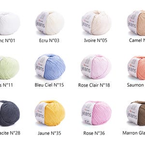 May include: A collection of twelve yarn balls in various colors, including white, beige, light green, blue, pink, and brown. Each ball has a label with the word "jeans" and a color name. The colors are labeled with numbers.