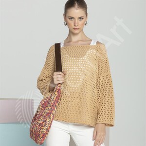 May include: A woman wearing a beige, open-weave sweater with a brown shoulder bag. The bag has a colorful, patterned design. She is also wearing white pants and hoop earrings. The sweater has a loose fit and long sleeves.