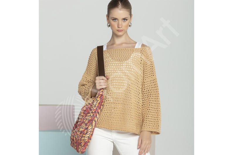 May include: A woman wearing a beige, open-weave sweater with a brown shoulder bag. The bag has a colorful, patterned design. She is also wearing white pants and hoop earrings. The sweater has a loose fit and long sleeves.