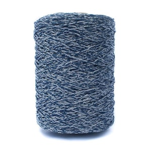 Peut inclure: Une bobine cylindrique de fil, principalement bleue avec un subtil effet marbré blanc. Le fil est étroitement enroulé, créant une surface texturée. Idéal pour les projets de tricot ou de crochet.