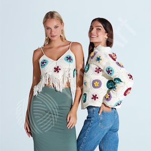 May include: Two women modeling crochet tops and a jacket. The white crochet top has a fringe hem and colorful floral designs. The jacket is also white with similar floral patterns. One woman wears a green skirt, the other blue jeans.