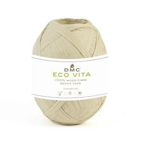 Op de afbeelding: Een bol beige raffia garen met een wit etiket met de tekst "DMC ECO VITA 100% WOOD FIBRE RAFFIA YARN". Het garen is strak opgerold, wat duidt op natuurlijke vezels, geschikt voor duurzaam knutselen.