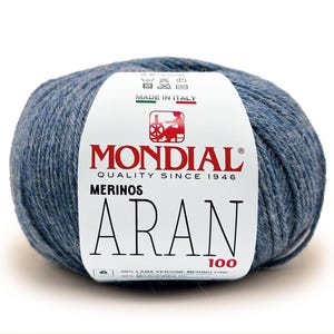 Peut inclure: Pelote de laine bleue avec une étiquette blanche. L'étiquette indique "MONDIAL QUALITY SINCE 1946 MERINOS ARAN 100" et "MADE IN ITALY". La laine est de poids Aran, adaptée aux projets de tricot et de crochet.