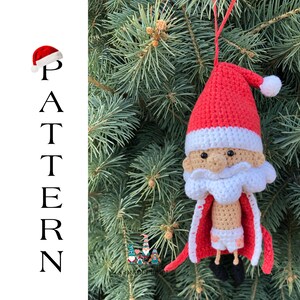 May include: A crocheted Santa Claus ornament hanging on a green Christmas tree. The ornament is red and white with a white beard and black eyes. The ornament has a red hat with a white pom-pom.