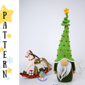 May include: Crocheted Christmas tree gnome with a green hat, white beard, and red beads. The gnome is standing on a white surface with a rocking horse and a small Christmas tree in the background.