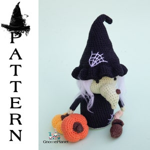 May include: Crocheted witch doll with a black hat and white hair, holding a small orange pumpkin. The doll is sitting on a light green background.