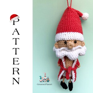 May include: Crocheted Santa Claus ornament with a red hat, white beard, and a red robe. The ornament is hanging from a white string.