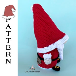 May include: A crocheted Christmas gnome with a red hat, white trim, and a white beard. The gnome is wearing a black belt and has brown shoes.