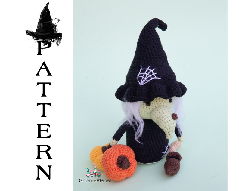 May include: Crocheted witch doll with a black hat and white hair, holding a small orange pumpkin. The doll is sitting on a light green background.