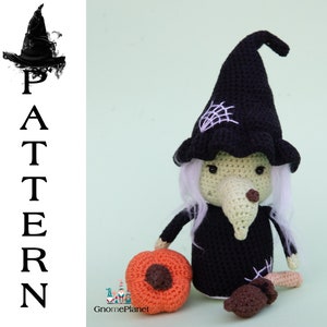 May include: Crocheted witch doll wearing a black hat, with white hair and a green face. The doll is holding a small orange pumpkin and a brown mushroom.