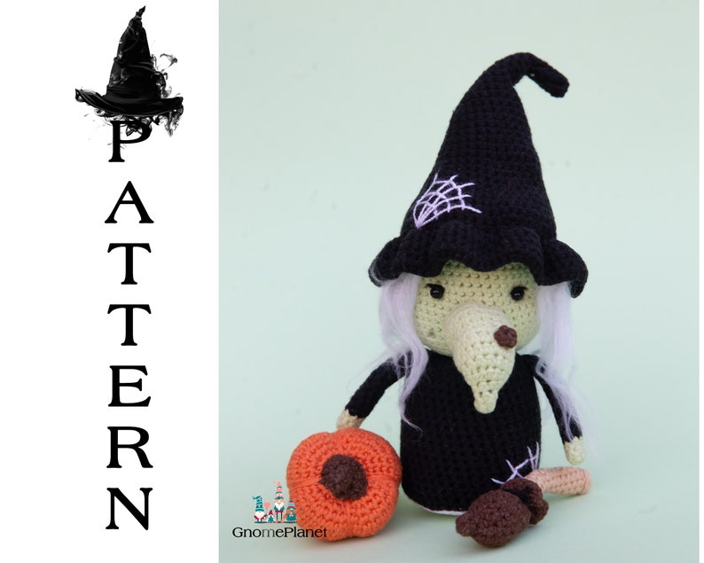 May include: Crocheted witch doll wearing a black hat, with white hair and a green face. The doll is holding a small orange pumpkin and a brown mushroom.