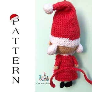 May include: Crocheted Santa Claus ornament with a red hat, white trim, and a long red tail. The ornament is made with red, white, and beige yarn.