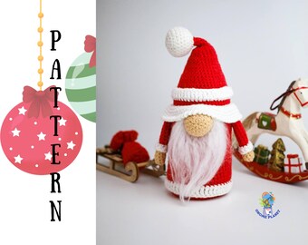 May include: A crocheted gnome with a red hat, white beard, and white trim. The gnome is standing on a white surface with a rocking horse and a small wooden sled in the background.