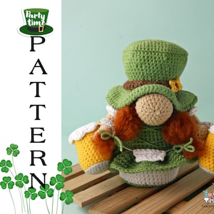 Può includere: Gnomo all'uncinetto con un cappello verde con una fibbia dorata e che tiene due boccali di birra gialli e bianchi. Il gnomo indossa un abito verde e bianco e ha i capelli rossi. Il testo "Party time" è sul cappello.